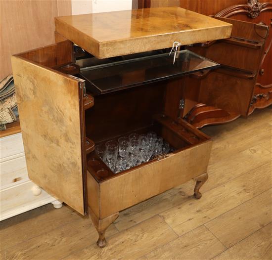 A 1930s walnut veneered cocktail cabinet, fitted with a part suite of vine etched drinking glassware W.70cm